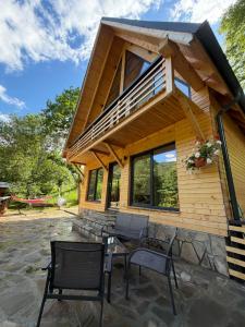 eine Blockhütte mit einem Glastisch und Stühlen in der Unterkunft Chalet Green in Cazaci