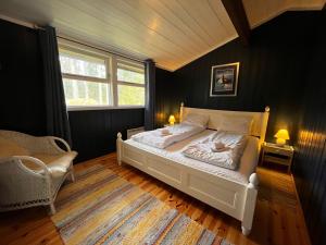 a bedroom with a white bed and a window at Villa Fregn in Ljørdalen