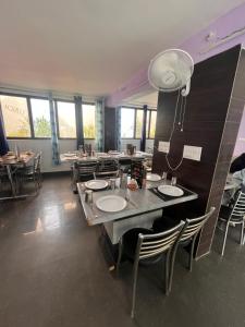 a dining room with tables and chairs and windows at Hotel AAA And Restaurant in Gupta Kāshi