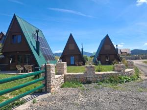 a group of cottages with a stone wall at Three Houses in Žabljak