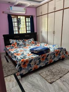 a bedroom with a bed with a floral comforter at Lara Homestay duplex 3bhk in Secunderabad +35 photos