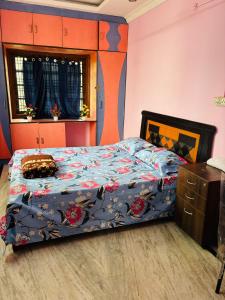 a bedroom with a bed with a blue comforter at Lara Homestay duplex 3bhk in Secunderabad