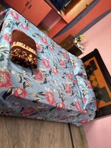 a couch with a blue cover with flowers on it at Lara Homestay duplex 3bhk in Secunderabad