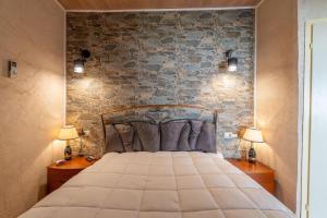 a bedroom with a bed with a stone wall at Casa Dimonte in San Siro