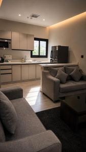 a living room with two couches and a kitchen at اجنحة الفخامة للشقق الفندقية in Taif