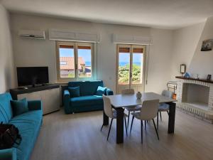 a living room with a table and a blue couch at Casa MedeFaby Due in S'archittu Cuglieri