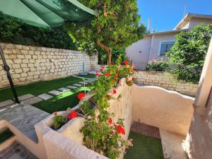 a garden with red flowers in a concrete planter at Casa MedeFaby Due in S'archittu Cuglieri