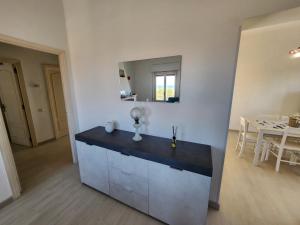 a kitchen with a counter and a dining room at Casa MedeFaby Due in S'archittu Cuglieri +21 photos