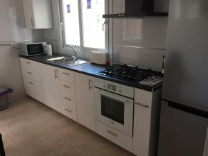 kuchnia z białymi szafkami i kuchenką w obiekcie Apartamento Mateos w Murcji