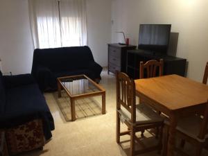 salon z kanapą, stołem i telewizorem w obiekcie Apartamento Mateos w Murcji
