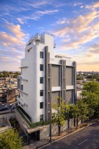 a white building with trees in front of it at Evara-Meraki Inn in Kolkata