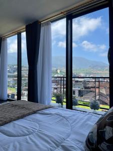 a bedroom with a bed and large glass windows at Kaffana Cabin House in Banjarnegara