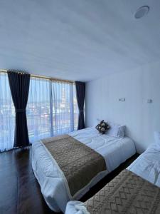 a bedroom with two beds and a large window at Kaffana Cabin House in Banjarnegara +3 photos