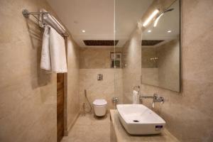 a bathroom with a sink and a toilet at Evara-Meraki Inn in Kolkata