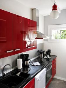 a kitchen with red cabinets and a black counter top at Sogno dOro in Germignaga +5 photos