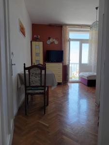 a room with a table and a chair and a bedroom at Villa BORIĆ DARKO in Podgora