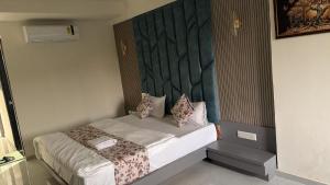 a bedroom with a bed with a headboard at Hotel Runway in Vadodara