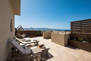 a patio with chairs and tables on a balcony at DOM Boutique Hotel in Heraklio