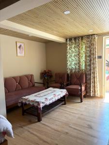 a living room with a couch and two chairs at Oliway Homestay in Lohaghāt