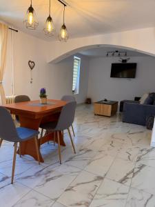 a living room with a wooden table and chairs at Casa NIB Calimanesti in Călimăneşti