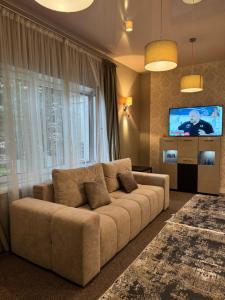 a living room with a couch and a flat screen tv at Villa Sofia in Odesa