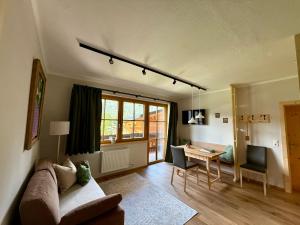 a living room with a couch and a table at Pension Möslehnerhof in Ramsau am Dachstein