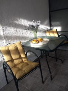 a glass table with a chair and a plate of fruit at ApartmaniNET in Krašići +9 photos