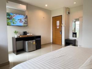 a bedroom with a bed and a tv on the wall at U Dee Room and Coffee in Kanchanaburi City