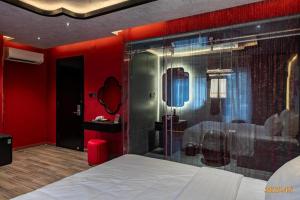 a bedroom with a shower and a bed and red walls at Midas Hotel 2 in Ho Chi Minh City
