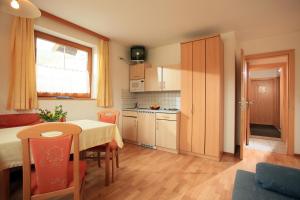 a kitchen with a table and a dining room at Appartements Gamper - Alpline Appartements KG in Brixen im Thale