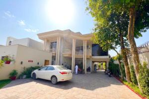 a white car parked in front of a building at Shelton Rezidor House F-8 Islamabad in Islamabad