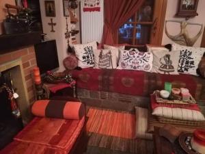 a living room with a bed with pillows and a fireplace at Δάσος ΜΕ ΠΛΑΤΑΝΙΑ in Agios Dimitrios