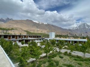 a view of a building with mountains in the background at Sost Embassy Hotel By Zeez in Khudābād