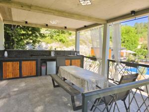 a patio with a table and a kitchen on a deck at Villa Krivokapic in Trebinje