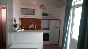 a kitchen with white cabinets and a stove top oven at ApartmaniNET in Krašići