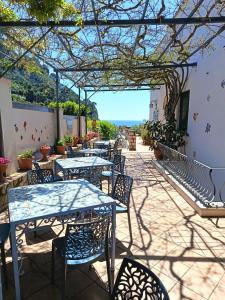 a patio with tables and chairs with a view of the ocean at Hotel 4 Stagioni in Capri