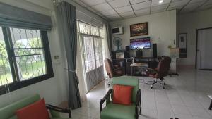 a waiting room with chairs and a desk and a tv at Lamphun Garden Home in Lamphun