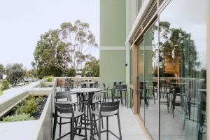 a restaurant with chairs and tables on a balcony at Punthill Epping in Epping