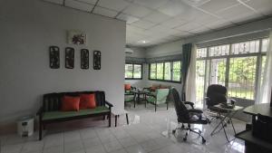 a living room with a couch and chairs and a table at Lamphun Garden Home in Lamphun