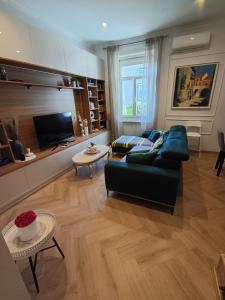 a living room with a couch and a tv at Apartman Beti in Opatija