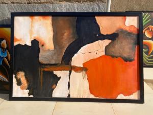 a painting in a black frame on a wall at INTAGARA Handcrafts in Butare