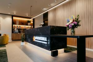 a lobby with a black counter with flowers on it at Punthill Epping in Epping