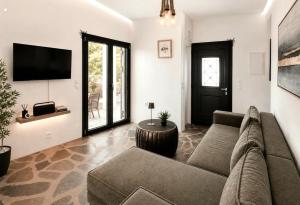 a living room with a couch and a tv at VILLA MIPA Samos in Kámpos