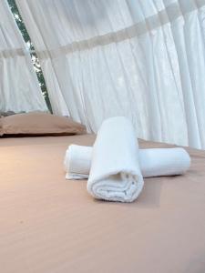 two towels on a bed in a tent at Under the Stars Domes in Shkodër +16 photos