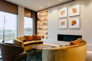 a living room with two chairs and a fireplace at Punthill Epping in Epping