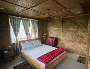 a bedroom with a bed with a red blanket at Rangdu Homestay in Darjeeling