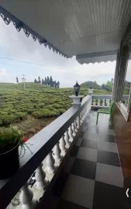 a balcony of a house with a view of the ocean at Rangdu Homestay in Darjeeling