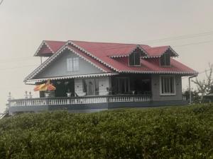 a house with a red roof on a hill at Rangdu Homestay in Darjeeling
