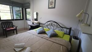 a bedroom with a large bed with pillows on it at Lamphun Garden Home in Lamphun