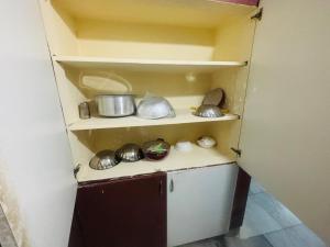 a small kitchen with pots and pans on shelves at Lara Homestay 2bhk in Secunderabad +32 photos
